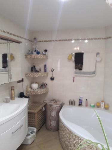 ein weißes Badezimmer mit einer Badewanne und einem Waschbecken in der Unterkunft Gemütliche Zimmer in Kaisersesch
