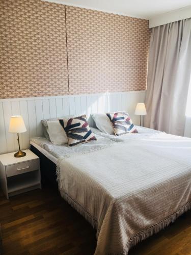 a bedroom with a bed with two pillows on it at Lomatila Ollila Farm Stay in Kerimäki