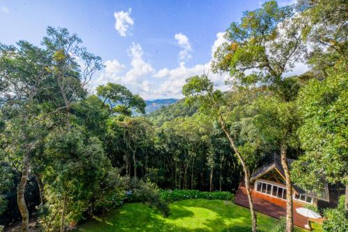 a house in the woods with a green yard at La Réserve Suites in Monte Verde