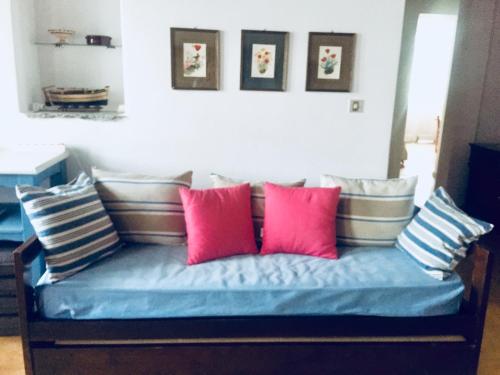 kanapę z różowymi i niebieskimi poduszkami w obiekcie House in Kamares - Sifnos w mieście Kamárai