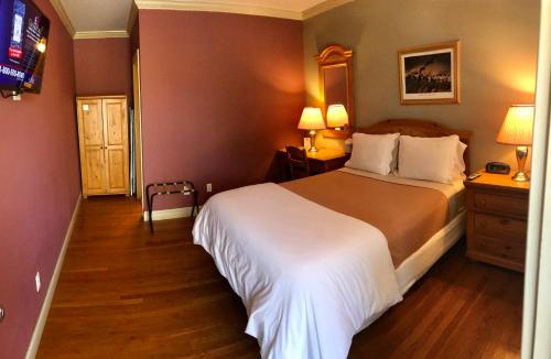 a bedroom with a large bed and a tv at Southampton Long Island Hotel in Southampton