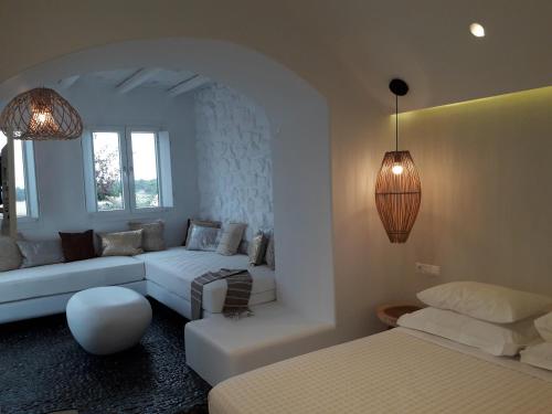 a white living room with a couch and a table at Villa Faros in Aliko Beach