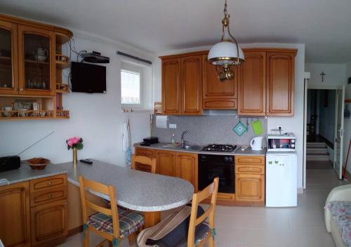 a kitchen with wooden cabinets and a table with chairs at Villa Venezia in Egerszalók
