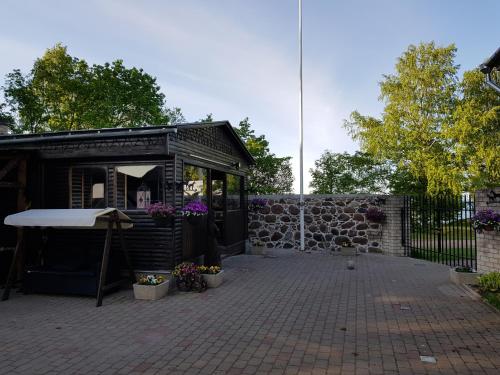 a small shed with a table and a stone wall at Nina puhkemaja in Nina