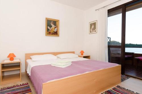 a bedroom with a bed with a purple blanket at Apartments Anica in Sobra