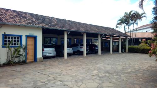 a building with cars parked in a parking lot at Pousada Berço da Liberdade in Tiradentes