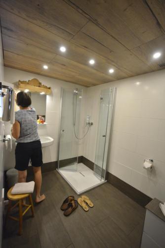 a woman taking a picture of a shower in a bathroom at Schmiedhof in Seefeld in Tirol