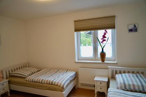 a bedroom with two twin beds and a window at M&A Ferienwohnungen Oberbayern in Peiting