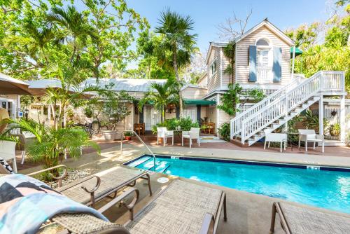 uma casa com piscina em frente a uma casa em Andrews Inn & Garden Cottages em Key West