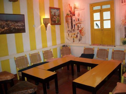 a dining room with two tables and chairs and a door at Hotel Santa Prisca in Taxco de Alarcón