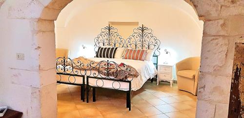 a bedroom with a bed with a ornate headboard at Palazzo Rodio in Ostuni
