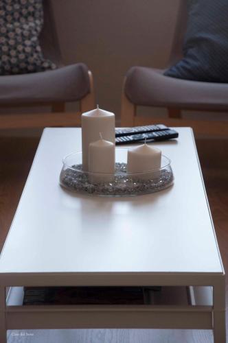 a white coffee table with two candles on it at Casa Del Beso in Luarca