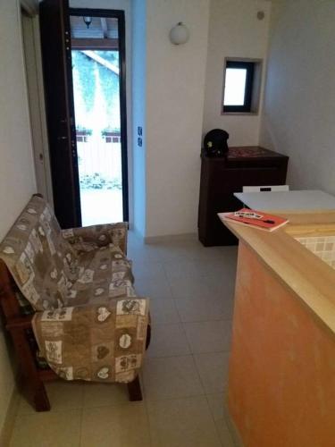 a room with a chair and a kitchen with a counter at Il rifugio del conte in Conversano