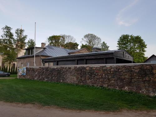 a large house behind a stone wall with a fence at Nina puhkemaja in Nina