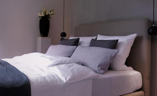 a white bed with a bunch of pillows on it at Die Hütten Appartements in Poseritz