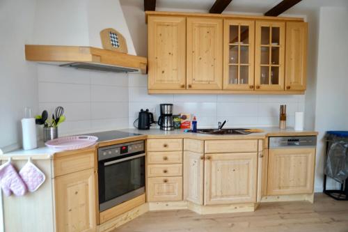 a kitchen with wooden cabinets and a sink at M&A Ferienwohnungen Oberbayern in Peiting