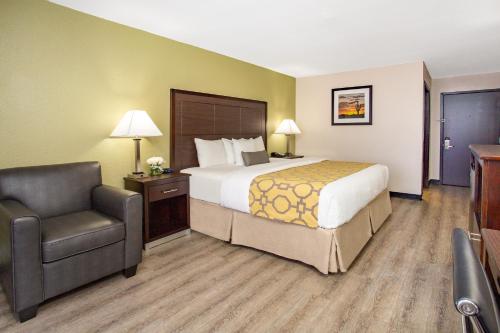 um quarto de hotel com uma cama e uma cadeira em Baymont by Wyndham Phoenix I-10 near 51st Ave em Phoenix