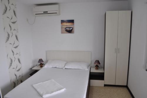 a small bedroom with a white bed and a cabinet at Complexul Turistic Class in Sulina
