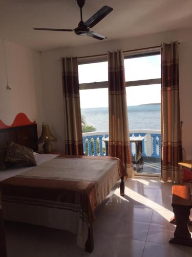 a bedroom with a bed and a view of the ocean at Coco Villa in Mahébourg