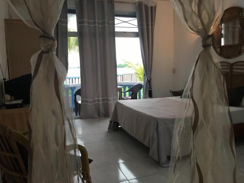 a bedroom with a bed and a table and a window at Coco Villa in Mahébourg
