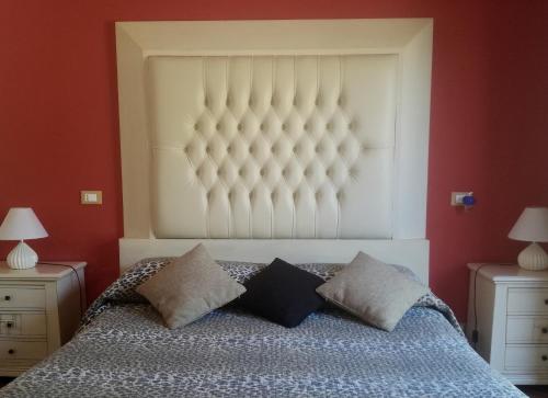 a bedroom with a large bed with two pillows at Villa Delle Palme Delfina in Trapani