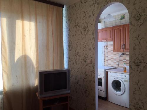 a kitchen with a tv and a washing machine at Apartment Telbin in Kyiv