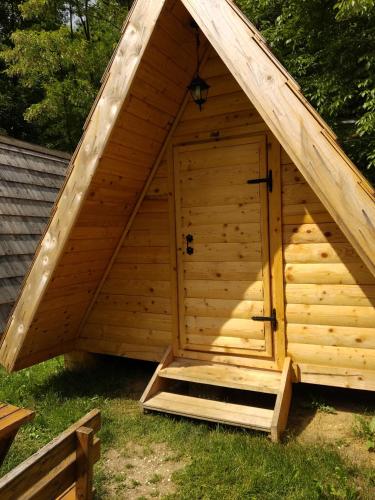 a large wooden doghouse with a pitched roof at Camp Vrbas in Rekavice