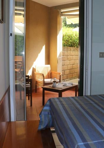 a room with a bed and a table and a patio at Appartamenti Boboli in Punta Ala