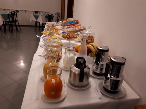a table with a buffet of food and orange juice at Hotel Ciclamino in Riolo Terme