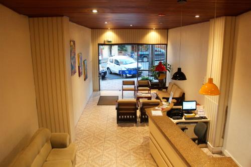 eine Lobby mit einem Wohnzimmer mit Sofa und Stühlen in der Unterkunft City Hotel in Caxias do Sul