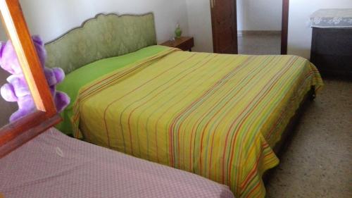 a bedroom with a bed with a green and yellow sheets at Porzione di villetta in Silvi Paese