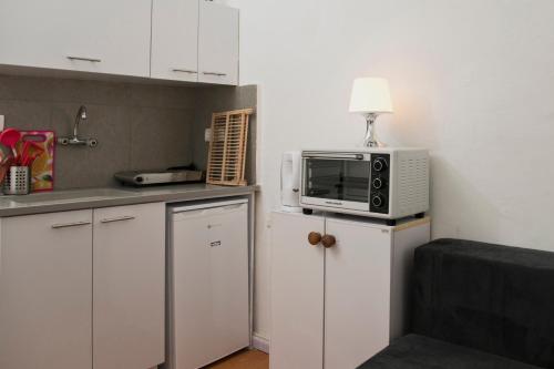 a kitchen with a microwave on top of a refrigerator at Sea Esta by the Beach in Tel Aviv
