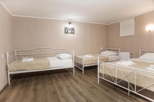 a room with two beds and two tables in it at Home25 in Tbilisi City