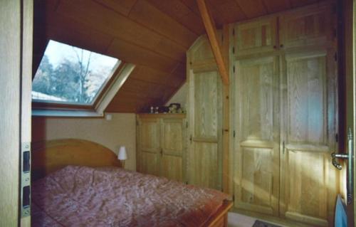a small bedroom with a bed and a window at Au pied du Markstein in Oderen