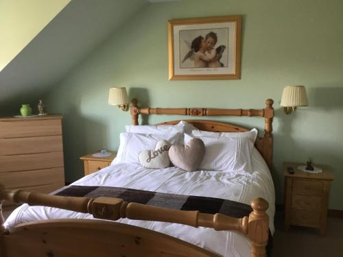 a bedroom with a bed with two dolls on the pillows at Woodcockfaulds House in Stirling