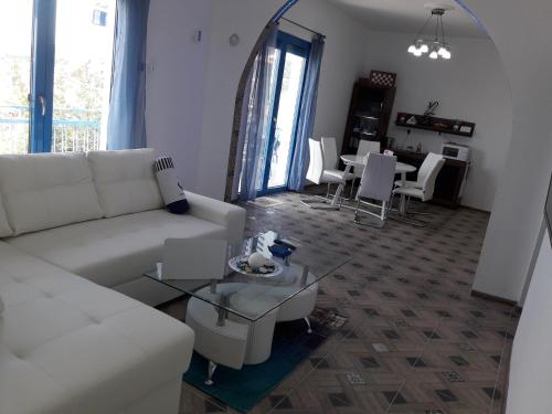 a living room with a white couch and a table at Island Apartment in Kavala