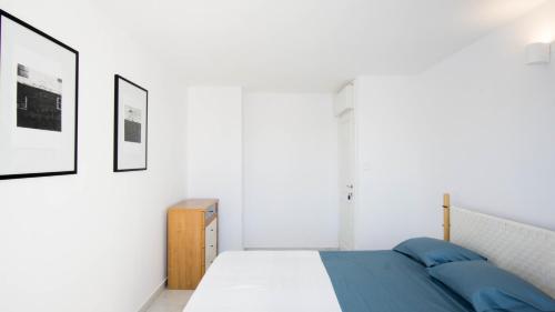 a bedroom with a bed and two pictures on the wall at Vila Visnjic in Grebaštica