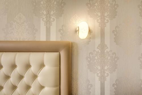 a bedroom with a bed and a light on a wall at Hotel Castel Vecchio in Castel Gandolfo
