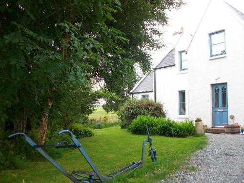 Una bicicleta estacionada en el césped frente a una casa en The Cosy Cabin, en Portree