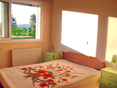 a bedroom with a bed with a flower blanket on it at Villa Giannopoulos in Áyios Ioánnis
