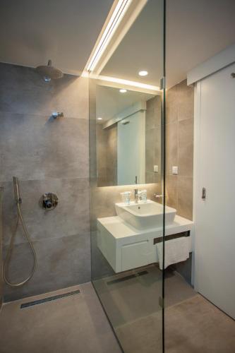 a bathroom with a sink and a glass shower at Hotel Delta in Fethiye