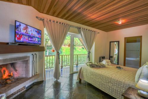 a bedroom with a fireplace and a bed and a television at La Réserve Suites in Monte Verde