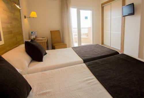 En eller flere senger på et rom på Hotel Guardamar