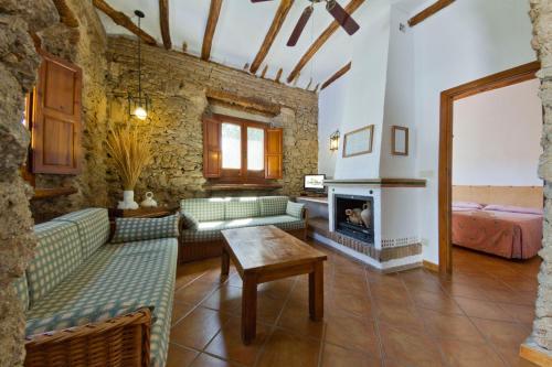 sala de estar con sofás verdes y chimenea en Cortijo Balzain, en La Zubia