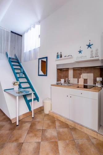 a kitchen with a blue staircase and a sink at Casa Calles in Siracusa