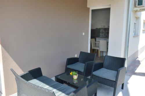 a patio with chairs and a table and a kitchen at Apartment Stipan in Bibinje