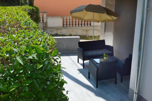a patio with a chair and an umbrella and a table at Apartment Stipan in Bibinje