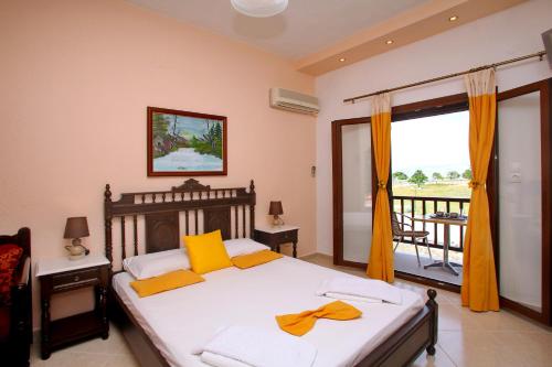 a bedroom with a bed with yellow pillows and a balcony at Maria Studios in Neo Klima