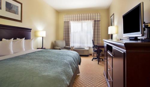 a hotel room with two beds and a television at Country Inn & Suites by Radisson, Pineville, LA in Pineville