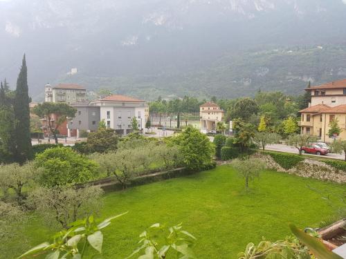 a green lawn in a city with houses and a mountain at Eagle Rooms in Riva del Garda